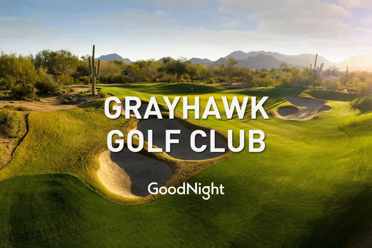 A wide shot of a beautifully maintained golf course, framed by sand traps, cacti, and distant mountains. The serene environment is perfect for leisure activities like golf outings or relaxed walks, providing stunning natural surroundings.